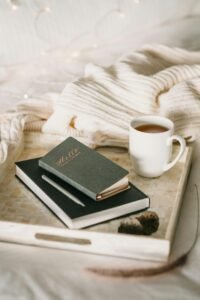 A cozy, sunlit room with a warm blanket, cup of tea, and an open journal a gentle self-care space.